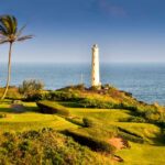 Check out the best things to do in Lihue Kauai recommended by top Hawaii blog Hawaii Travel Spot! Image of a little lighthouse surrounded by greenery