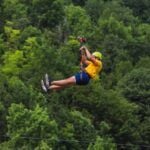 Find out where to go ziplining in Hawaii recommended by top Hawaii blog Hawaii Travel Spot. Image of a man ziplining over the rainforest