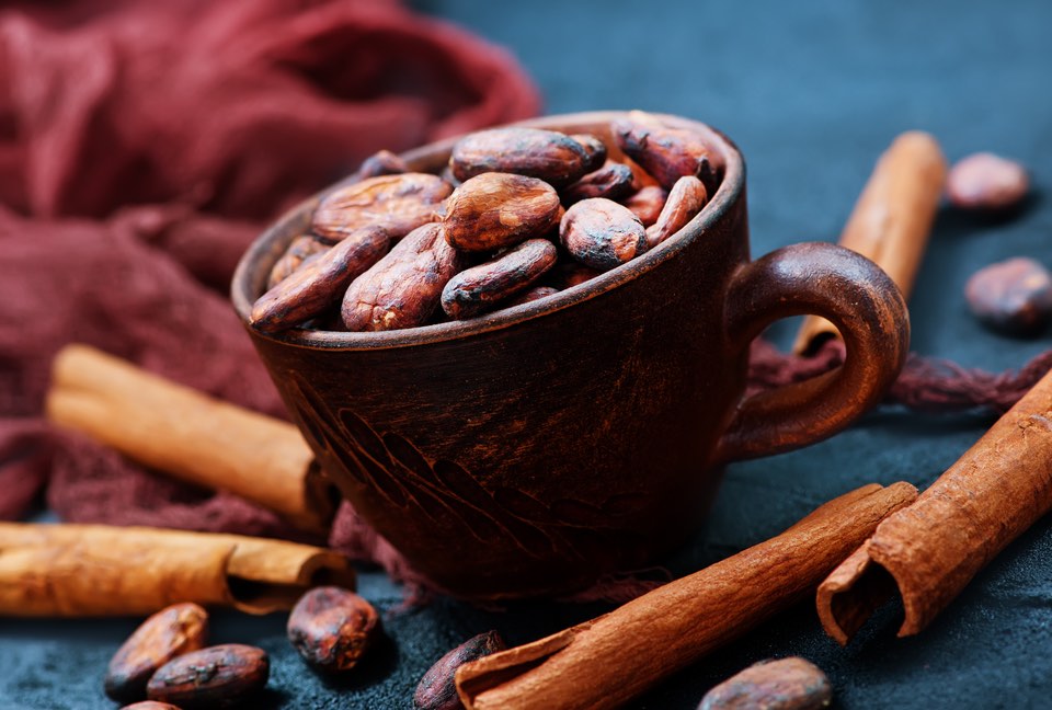 Image of cocoa beans in cup and on a table