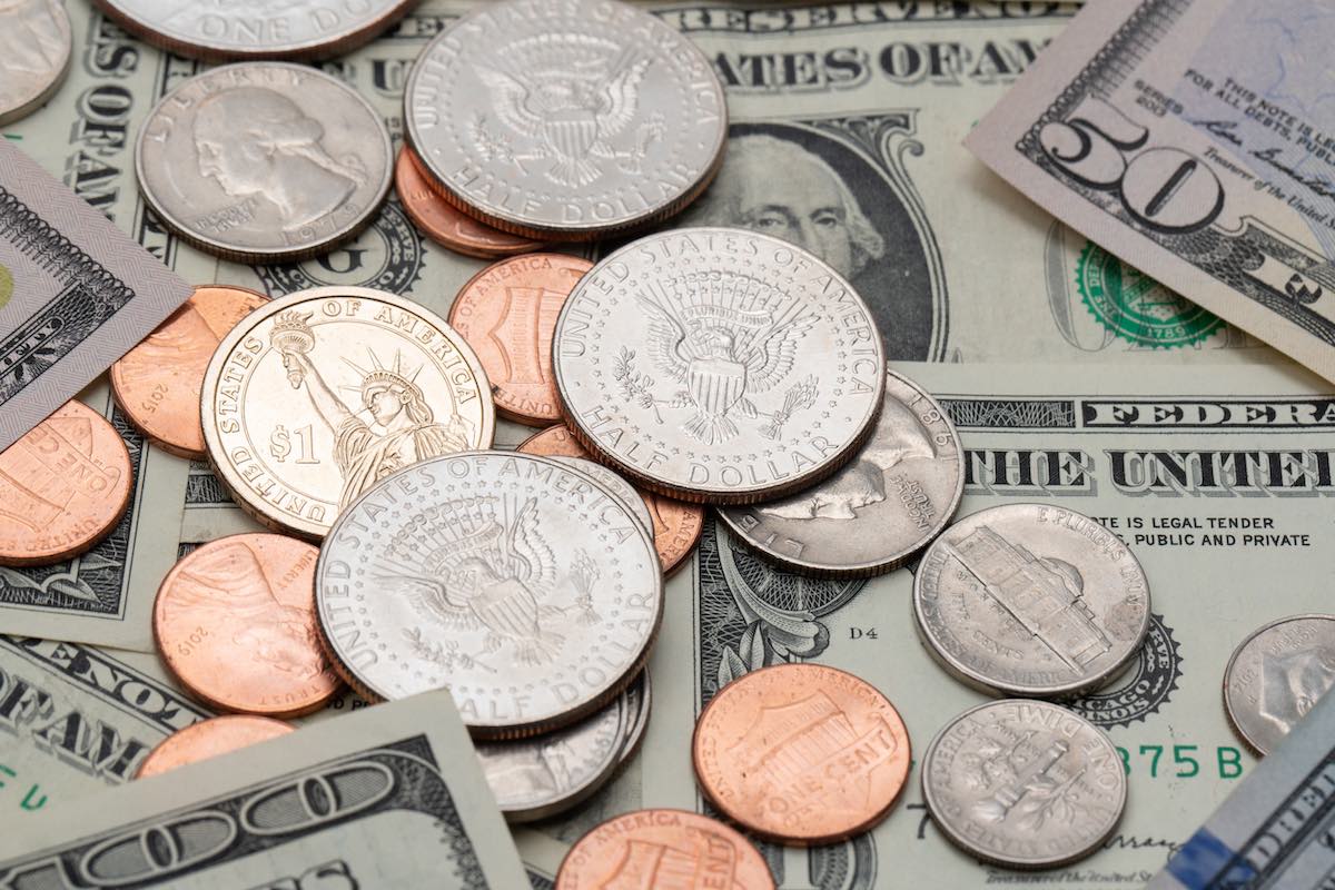 Check out this simple guide to tipping in Hawaii by top Hawaii blog Hawaii Travel Spot. Image of coins and dollars.