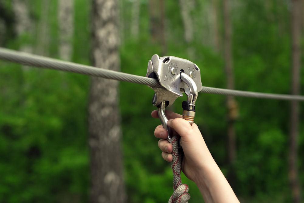 Image of a hand on a zipline harness