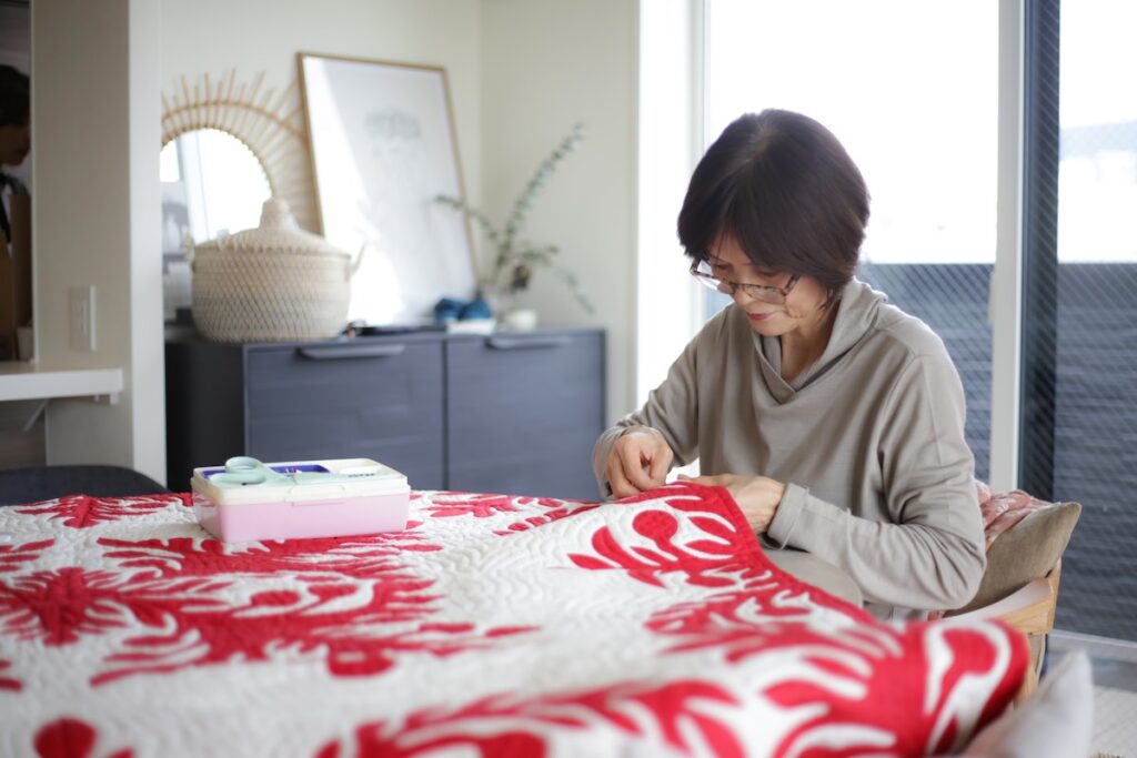 Image of a woman making a red Hawaiian quilt