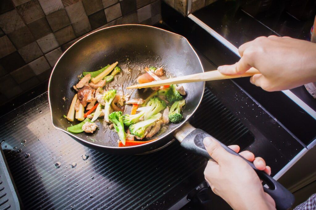 Image of someone stir frying veggies