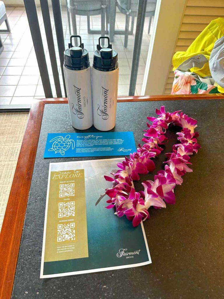 Image of reusable water bottles and a fresh flower lei