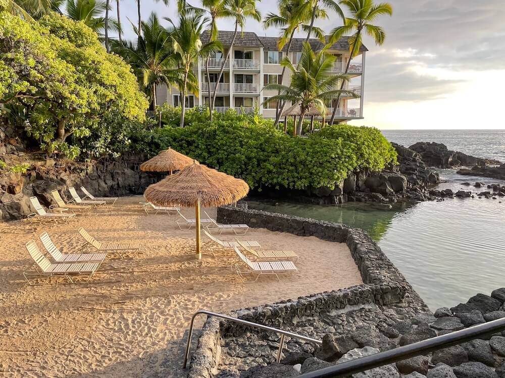 Image of a sandy beach with a lava rock wall