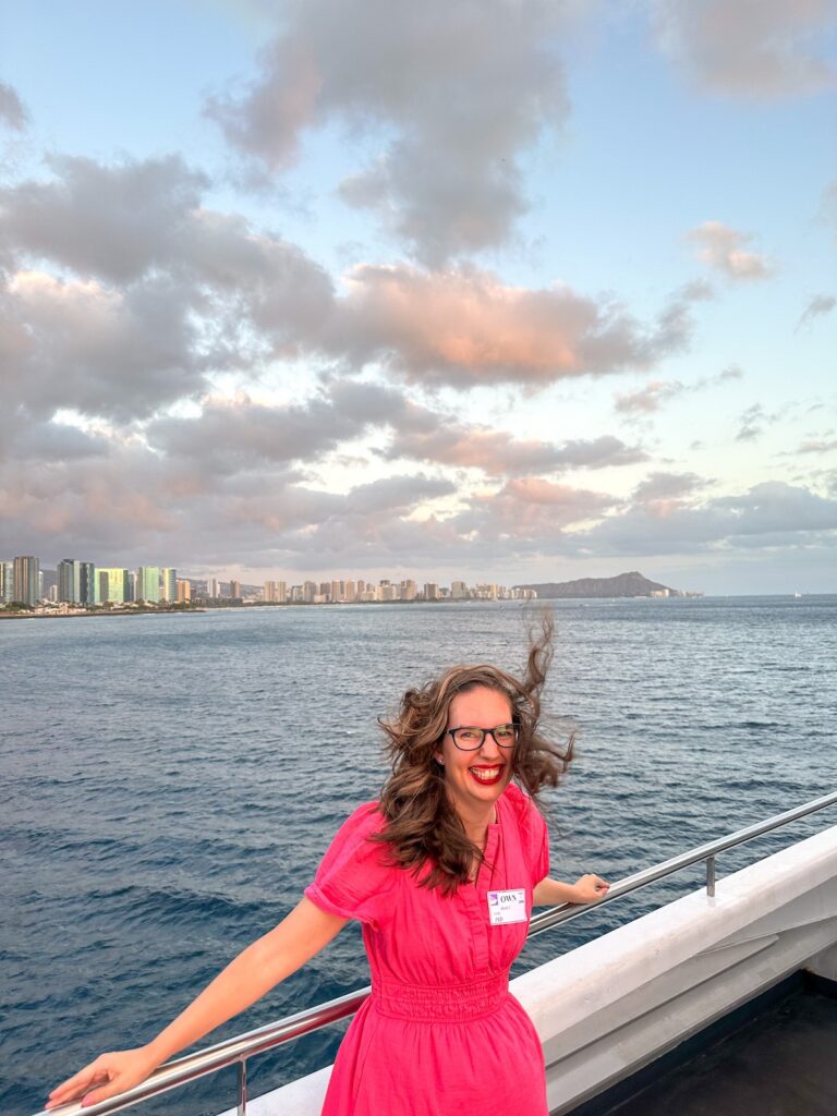 Image of Marcie Cheung of Hawaii Travel Spot on the Star of Honolulu dinner cruise deck with Diamond Head and Waikiki in the background